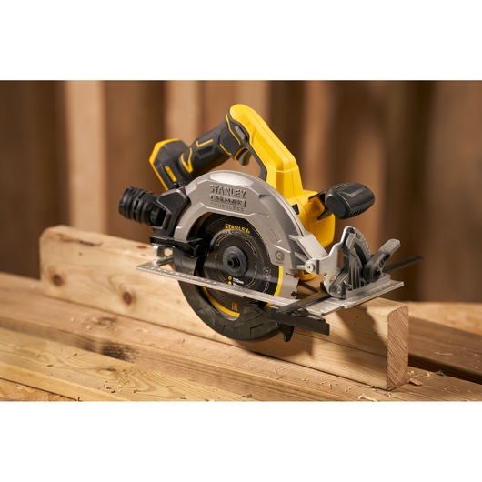 Photo of STANLEY SFMCS550B cordless circular saw cutting wood, yellow and black design, woodworking setting.