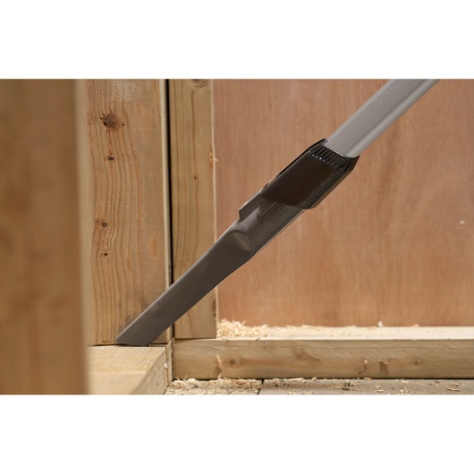 STANLEY SFMCVS001D1 vacuum crevice tool cleaning corner of wooden frame, close-up photography.