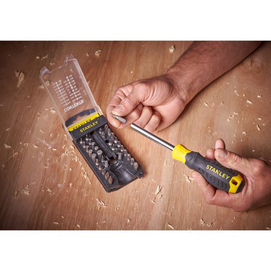 STANLEY STHT0-70885 screwdriver set with yellow and black handle and multiple bits on wooden surface.