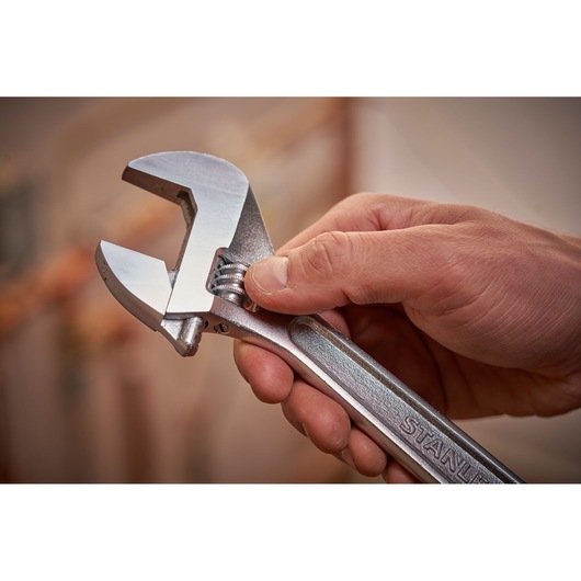 STANLEY STHT13121-0 adjustable wrench held in hand, silver finish, close-up photo.