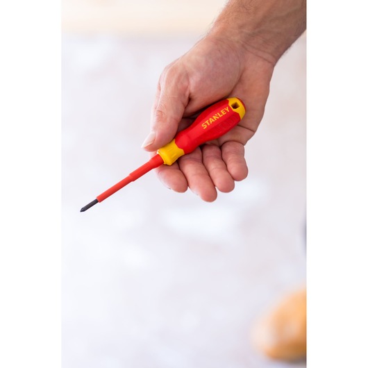 STANLEY STHT60032-0 red and yellow insulated screwdriver held in hand, close-up.