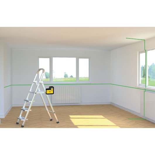 STANLEY STHT77594-1 laser level projecting green lines in a bright room, shown from front angle with ladder.