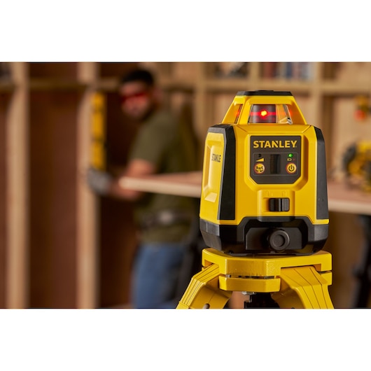 Photo of STANLEY STHT77616-0 yellow laser level on tripod, used for construction alignment.