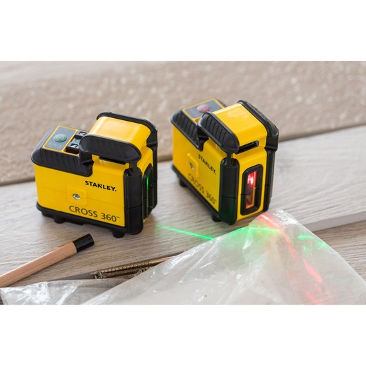 STANLEY STHT77640-1 yellow CROSS 360 laser level tools on wood surface, laser lines visible, photography angle.