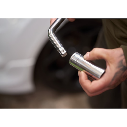 STANLEY STHT80890-0 socket wrench and socket in hand, close-up with car in background.