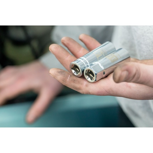 STANLEY STHT81583-0 chrome sockets held in a hand, close-up view, mechanic tool photography.