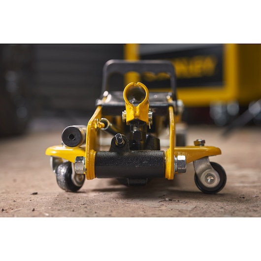 STANLEY STMT81251-1 yellow and black hydraulic floor jack close-up, front view on workshop floor.