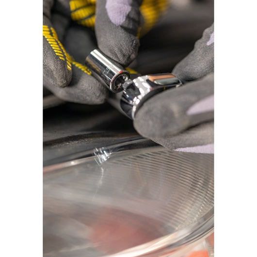 STANLEY STMT82828-1 socket tool held by gloved hand, close-up with reflective surface below.