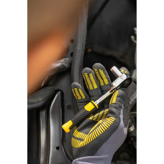 STANLEY STMT82828-1 ratchet wrench with black and yellow handle, held in gloved hand, close-up.