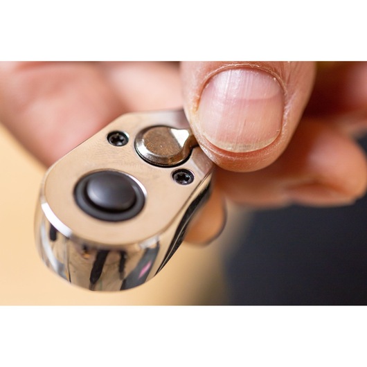 Photo of STANLEY STMT82828-1 ratchet head close-up with thumb pressing quick-release button.