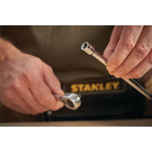 Photo of STANLEY STMT86007-0 ratchet and socket, close-up in hand, with tool belt visible.