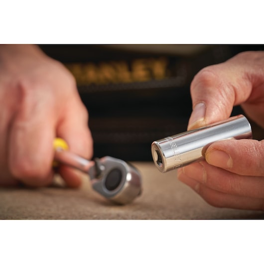 Photo of STANLEY STMT86096-0 socket tool in hand with ratchet, close-up view.