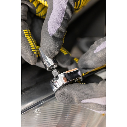 Photo of STANLEY STMT86109-0 socket being attached to ratchet wrench by gloved hands, close-up view.