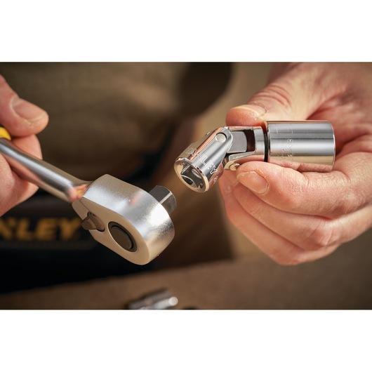 Photo of STANLEY STMT86211-0 socket and ratchet, close-up of hands connecting chrome tool parts.