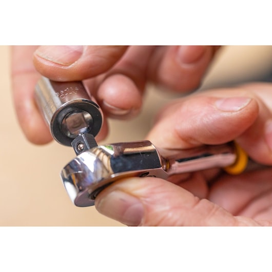 STANLEY STMT86316-0 ratchet wrench with socket, close-up photography of hand holding tool.
