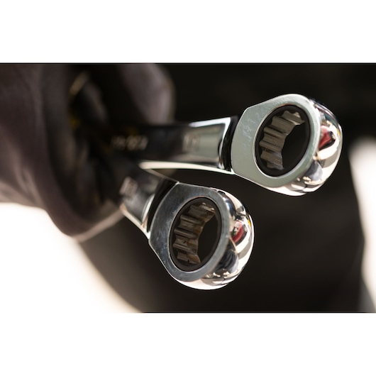 STANLEY STMT89910-0 photography of two chrome ratcheting wrenches held in a gloved hand, close-up view.