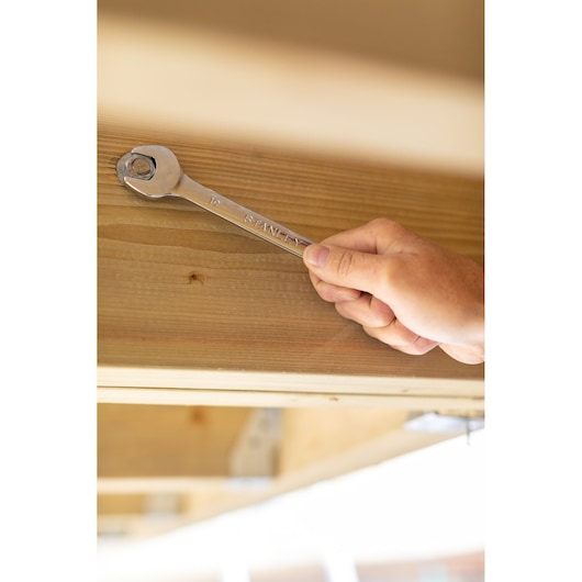 STANLEY STMT95909-0 wrench used on a bolt in wood, close-up angle, product photography.