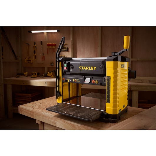 STANLEY STP18-B2 planer, yellow and black, photography in a workshop on a wooden table.