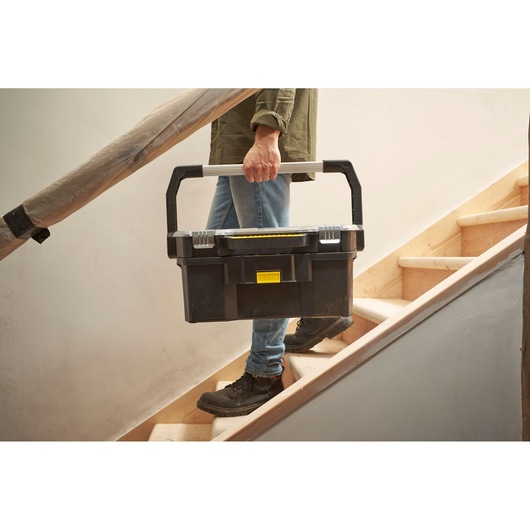 STANLEY STST1-70317 black toolbox with silver handle being carried up stairs, product photography.