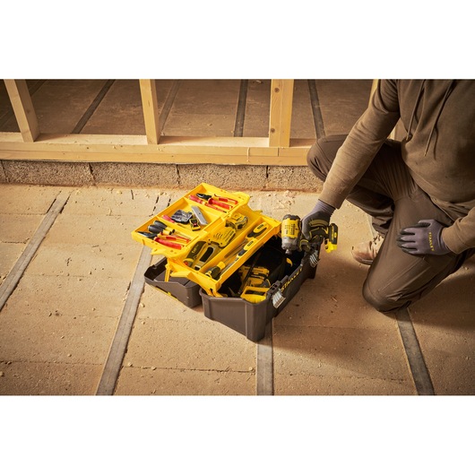 STANLEY STST83397-1 tool box open with assorted tools and drill in construction setting.