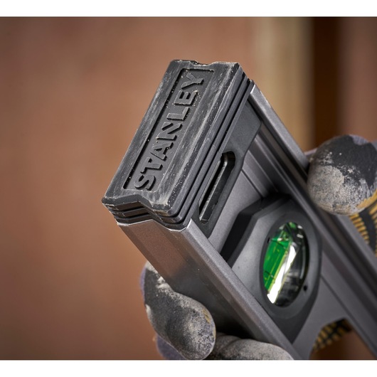 Photo of STANLEY XTHT1-42131 level tool held in gloved hand with visible green vial.